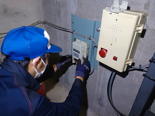 地震感知器の点検作業です。災害時に利用者を守る重要な装置です。エレベーターに関する様々な知識を覚え、3年も経てば一人前としてメンテナンスのプロに!