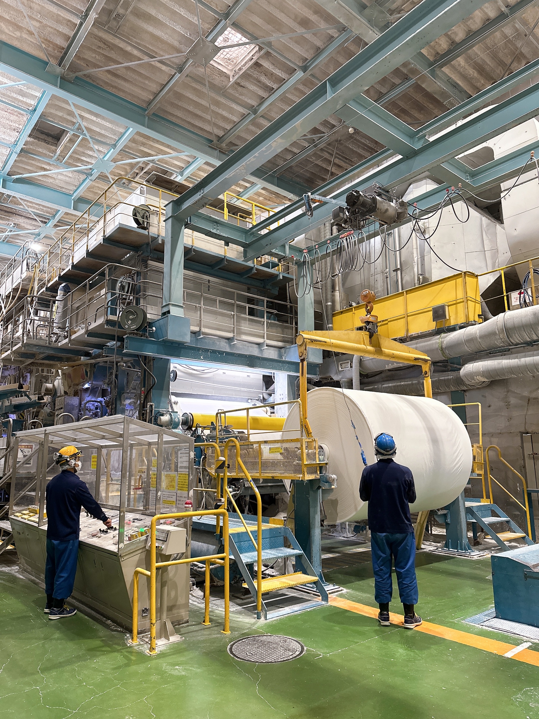 抄紙機から出来上がった原紙を取り出しています。