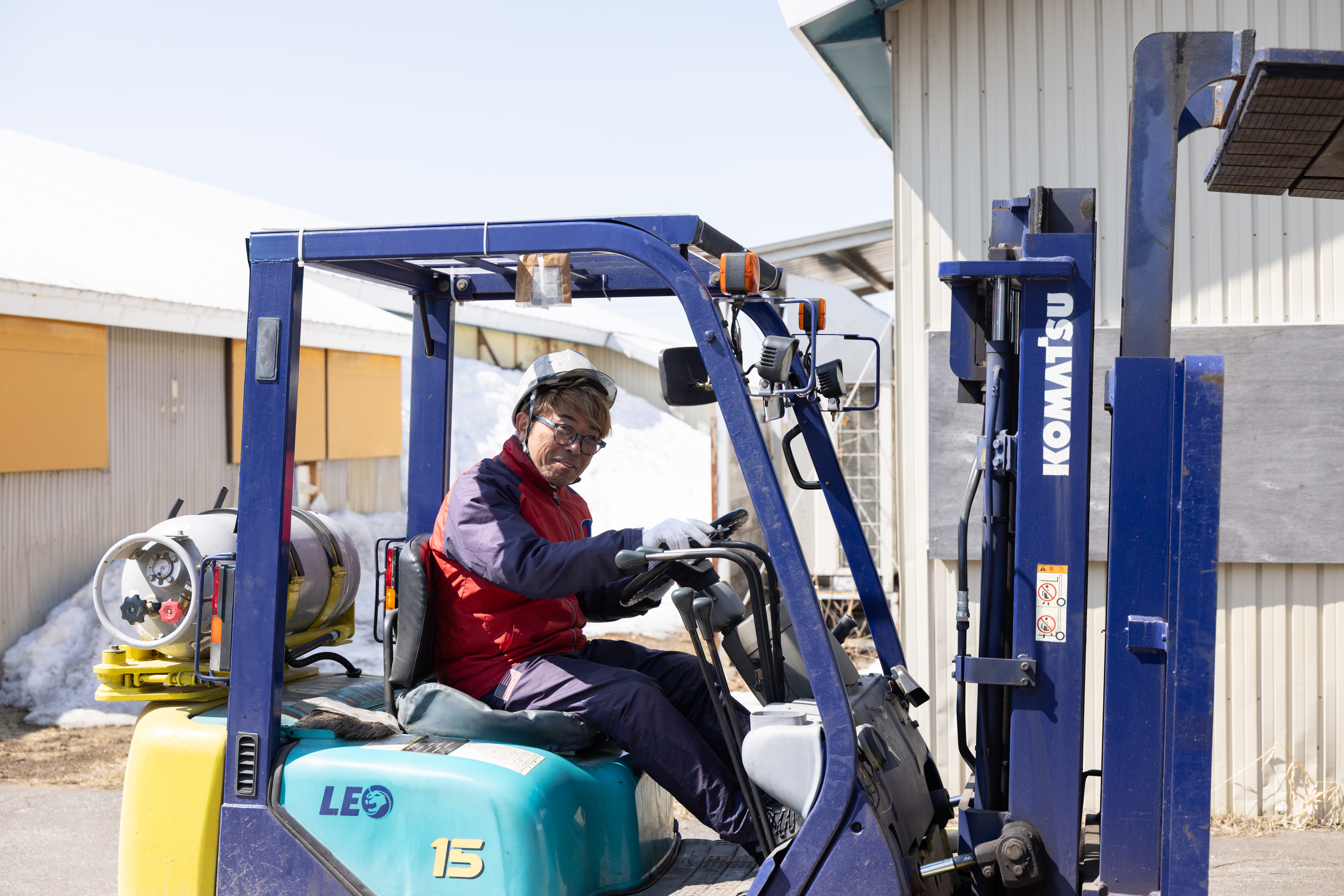 フォークリフト作業の様子。敷地内での操作がメインです。フォークリフト資格がない方は入社後に会社全額負担で取得可能です。写真のように当社では女性スタッフも運転しています。慣れれば操作も難しくないですよ！