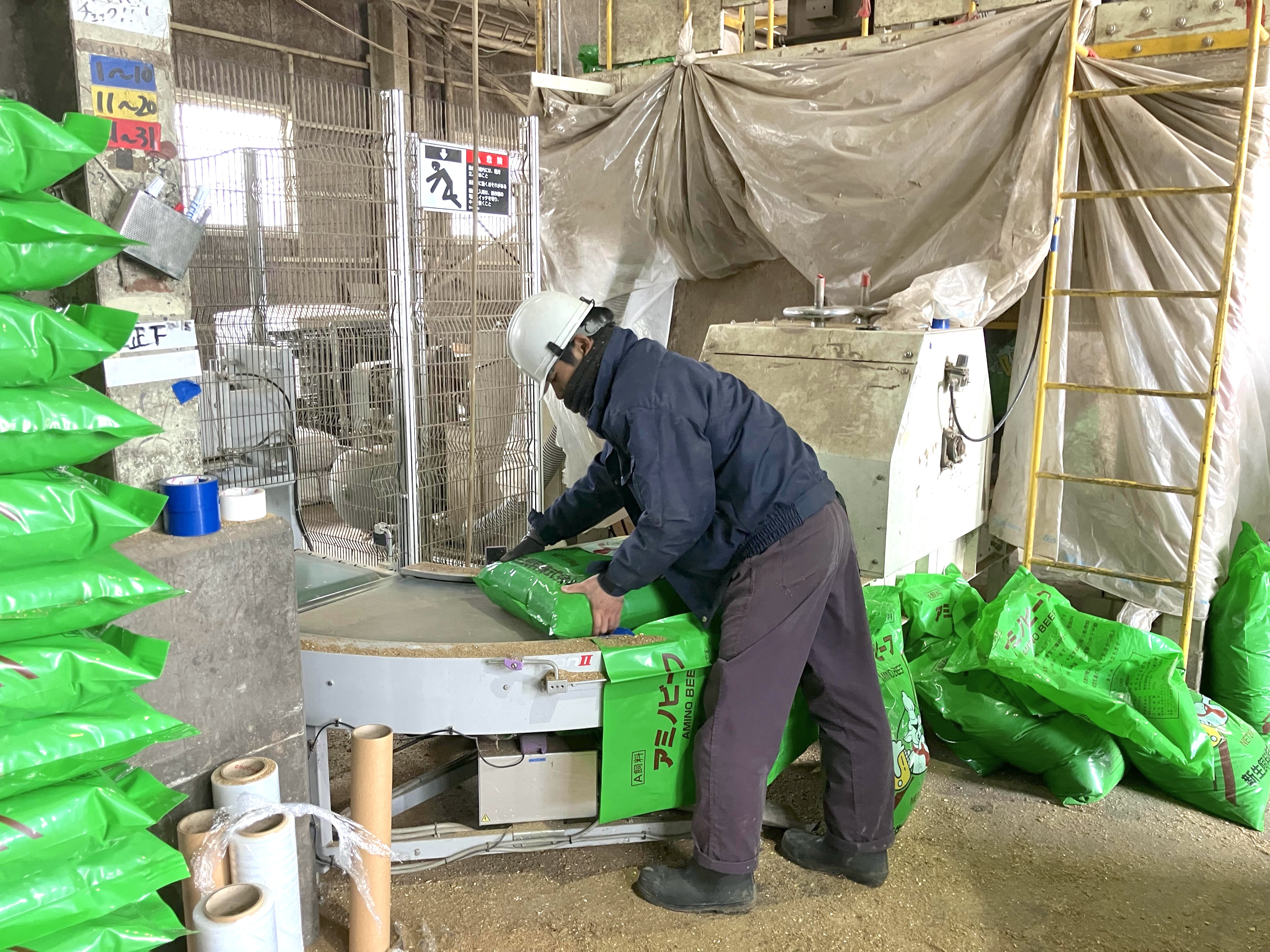 製品の移動作業の様子（一袋20kg）。シール部分の確認や形状を整える作業もあります。