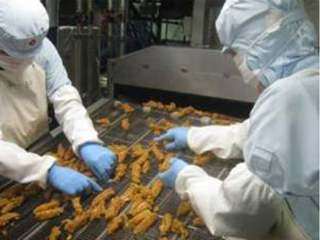 ＜各種ISO認証取得の当社工場＞
とても衛生的な工場です。北海道工場では約150名の方が働いています!写真は｢チキチキボーン｣の製造工程です。安心･安全な食品を提供する為、手作業でしっかりチェックします。