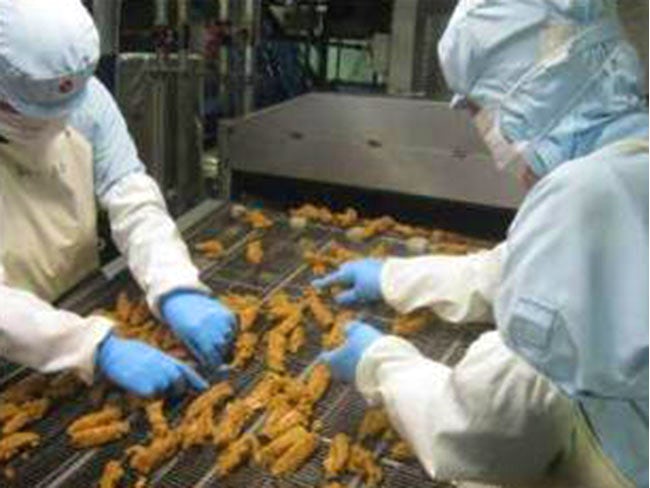 <各種ISO認証取得の当社工場>
とても衛生的な工場です。北海道工場では約150名の方が働いています!写真は「チキチキボーン」の製造工程です。安心・安全な食品を提供する為、手作業でしっかりチェックします。