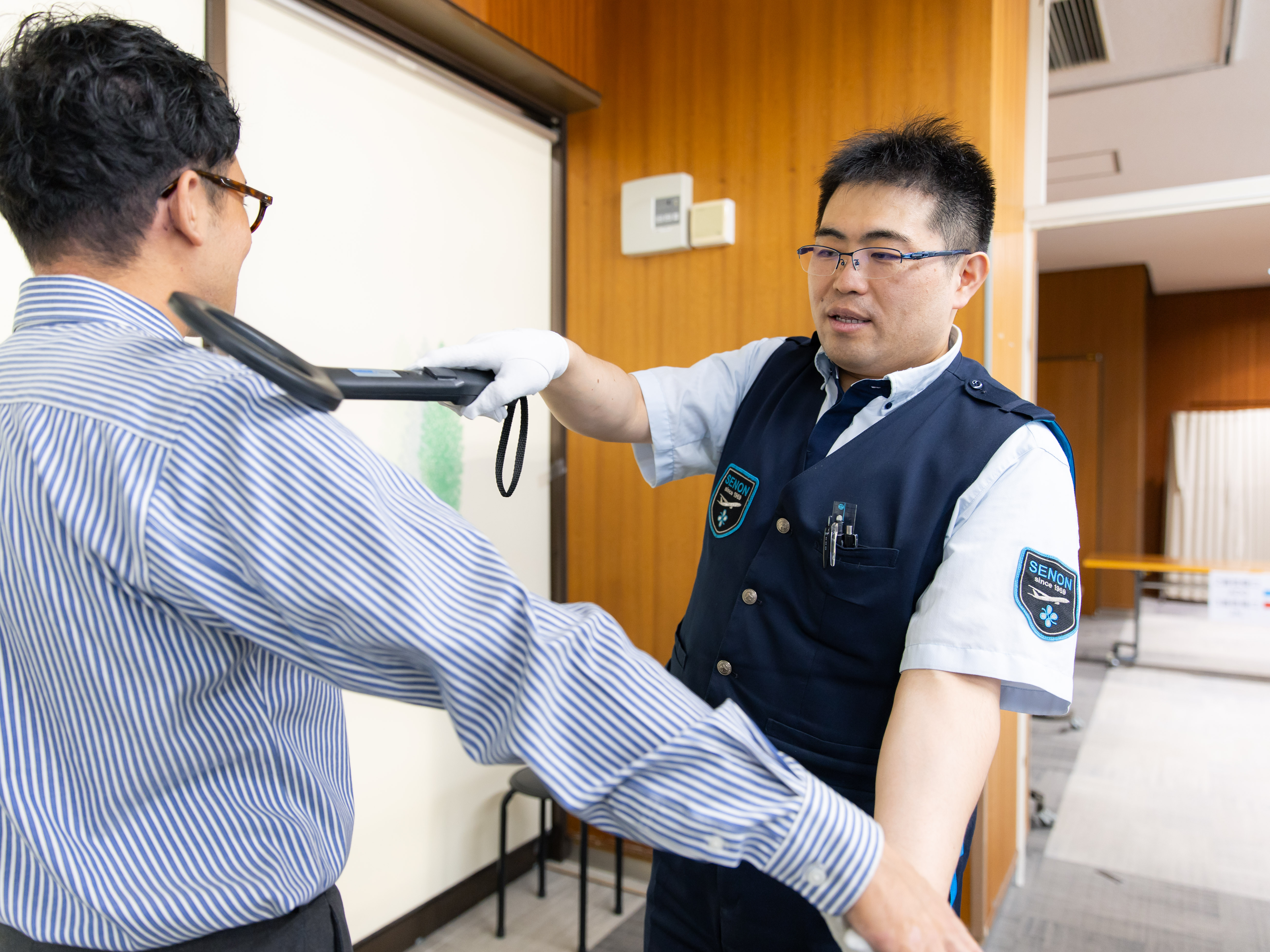 ボディチェックでは、専用の機械（金属探知機）を使って検査業務を行います。使い方は一つ一つしっかりとお教えしていきます。難しい内容ではないのでご安心を。きっとすぐに対応出来ると思います。