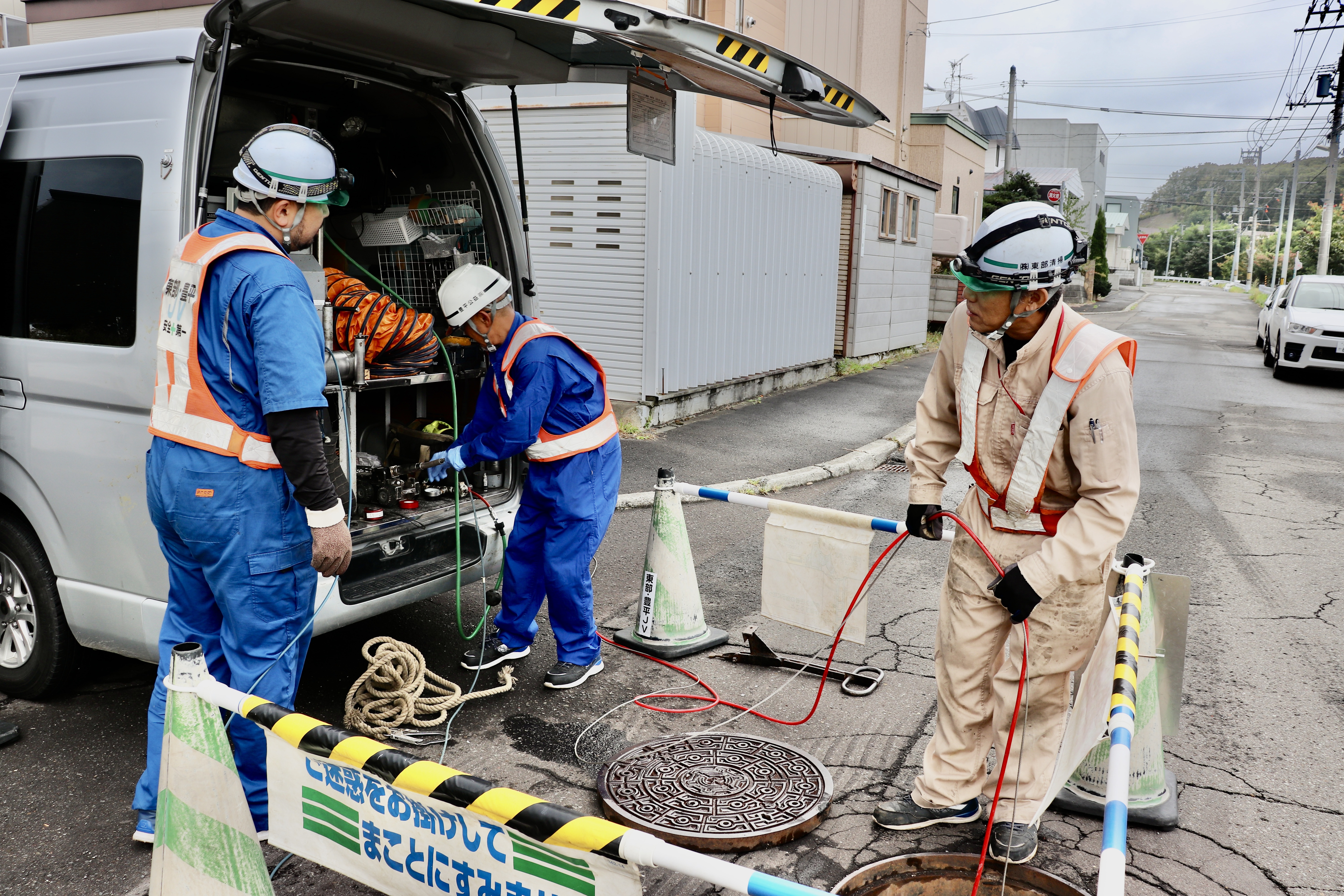 機械を上からマンホールに通していく人、マンホールの下に降りて機械を受け取る人、カメラを操作する人など、チーム内で業務を分担しながら進めていきます。