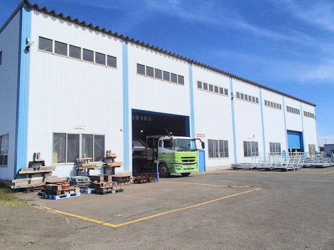 工場外観です。組み立てた製品は、ボルトなど必要な部品と一緒にトラックなどに積んで必要な現場へ送ります。重量物を積むときは機械で行うので安心ください。