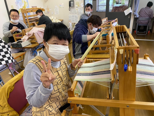 北の沢デイセンターは自宅やグループホームから通い、日中活動の場となる施設です。写真は「カランコ織」という手工芸をおこなっている場面です。