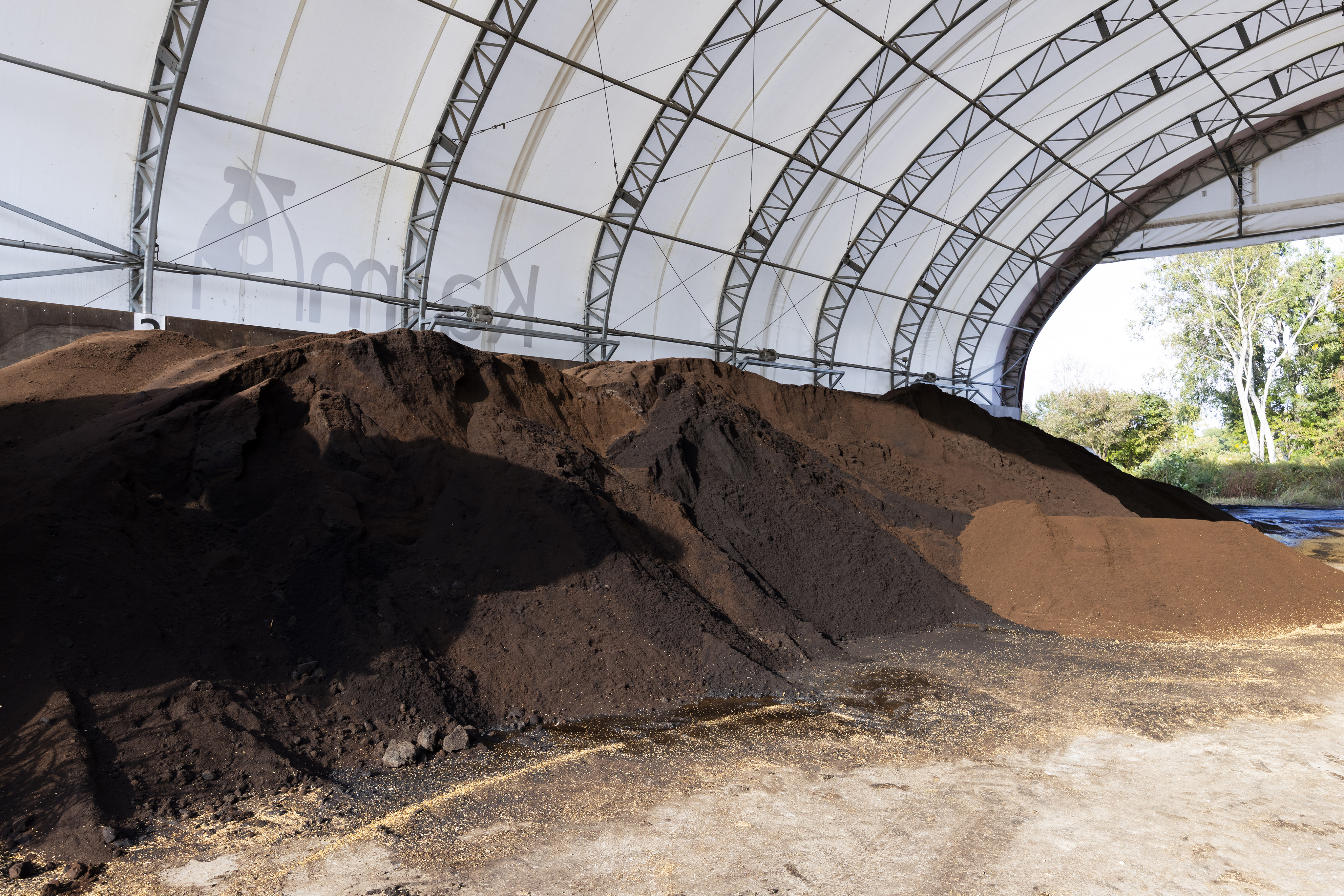 これはコーヒーを搾った後のコーヒーのかす。これを牛の寝床（ベッド）にしています。高い消臭効果があり、香ばしい珈琲の香りがします。他にもバイオガスプラントを敷設し､売電なども手掛けています。