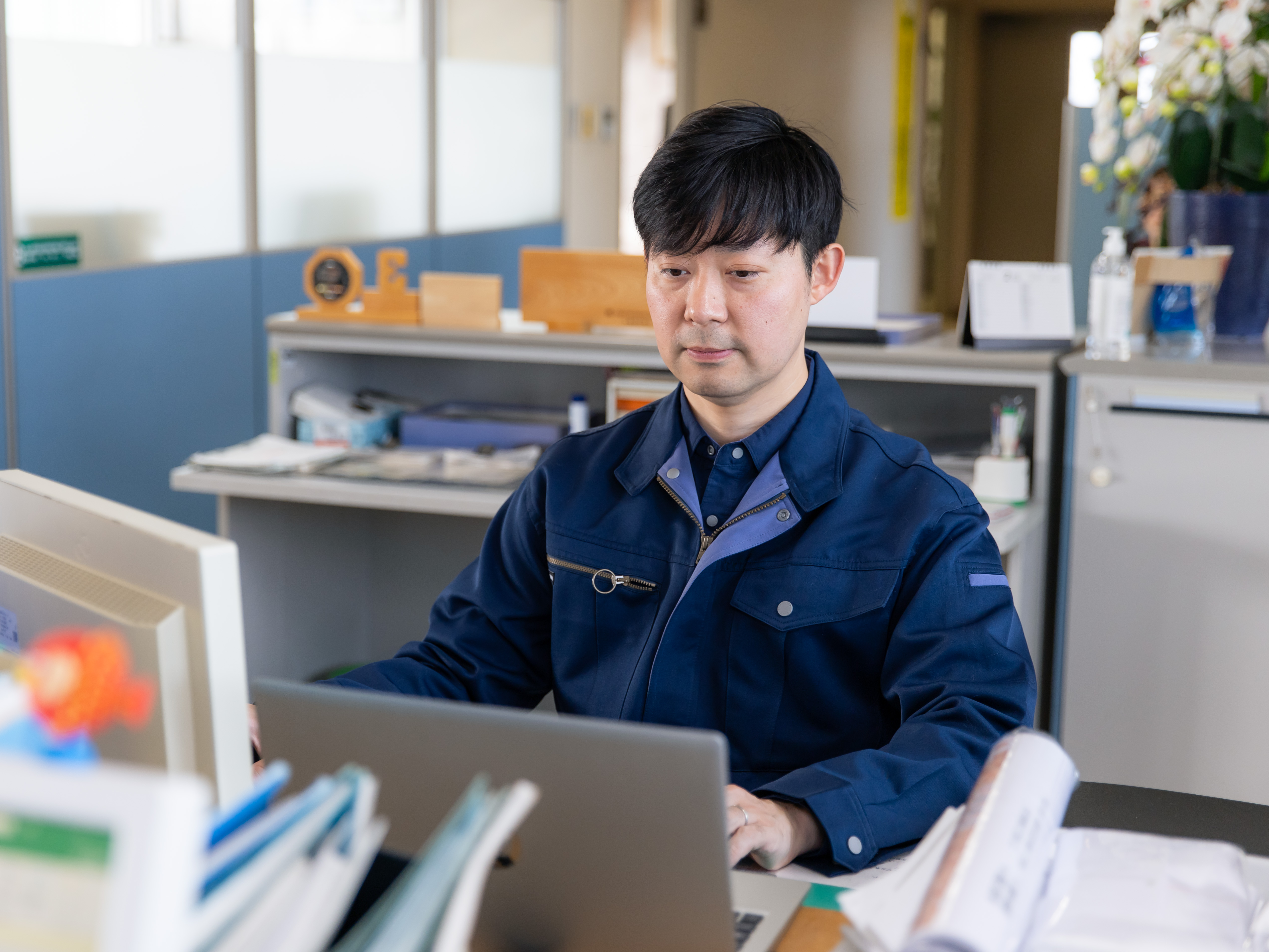 現場から戻ると、事務所では「お疲れさま！」と声が掛かります。重たい機器を扱う仕事だからこそ、事務作業中も助け合いの精神を忘れません。未経験からスタートした若手も、ここでじっくり知識を深めています。